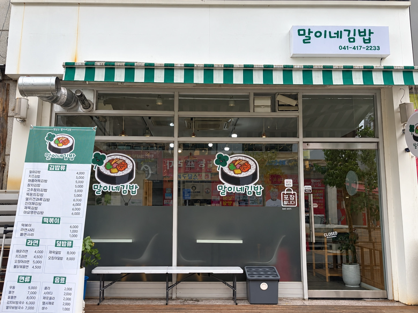 초록색 줄무늬 차양이 있는 말이네 김밥 매장 외관 보정 사진